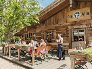 Blick auf die Q-Alm und die Sitzgelegenheiten im Außenbereich des Sieben Welten Hotel & Spa Resort