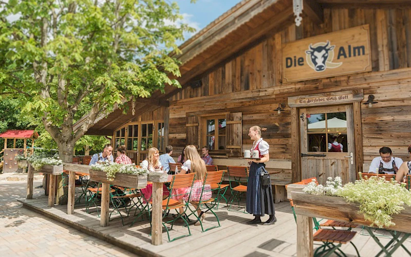 Blick auf die Q-Alm und die Sitzgelegenheiten im Außenbereich des Sieben Welten Hotel & Spa Resort