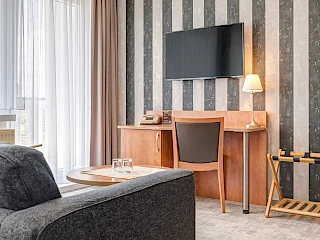 Einblick in das Hotelzimmer des Hotel Wilna in Erfurt aus einem anderen Blickwinkel mit Schreibtisch und Fernseher.