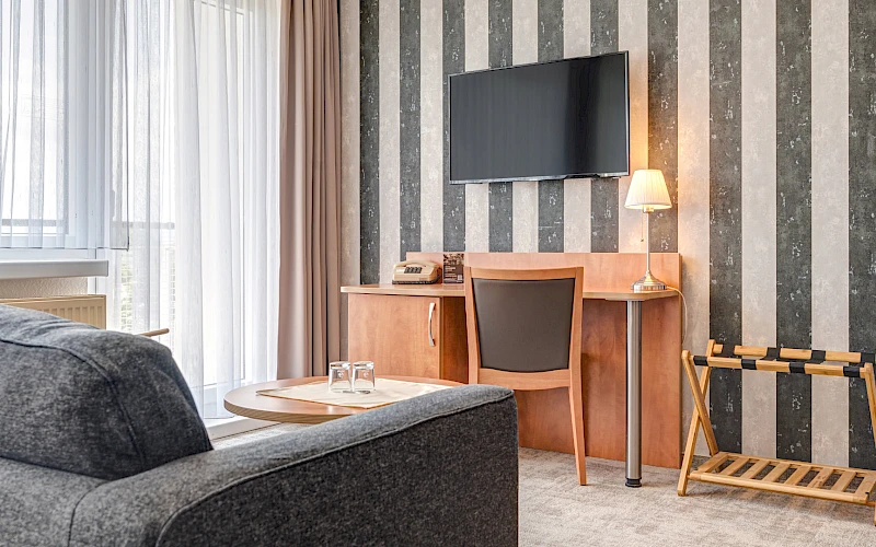 Einblick in das Hotelzimmer des Hotel Wilna in Erfurt aus einem anderen Blickwinkel mit Schreibtisch und Fernseher.