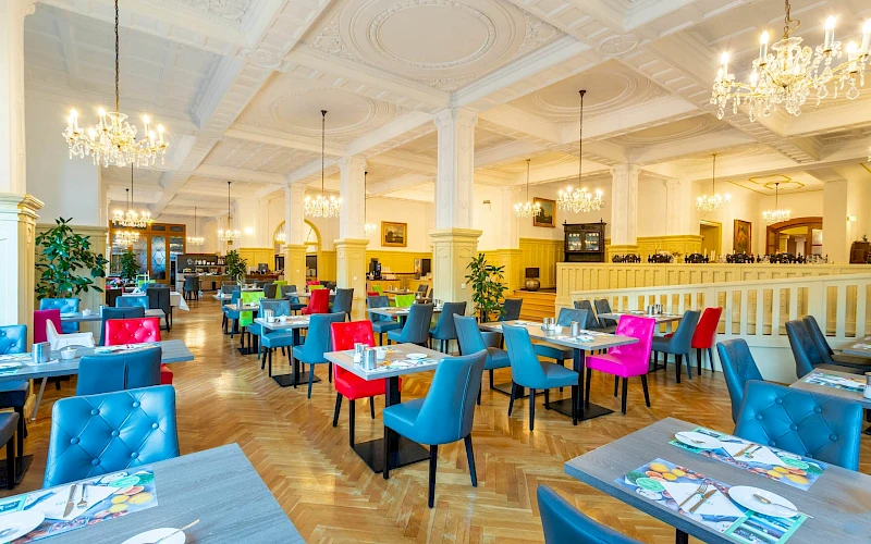 Blick ins Restaurant mit bunten Stühlen im Boutique Hotel Badehof